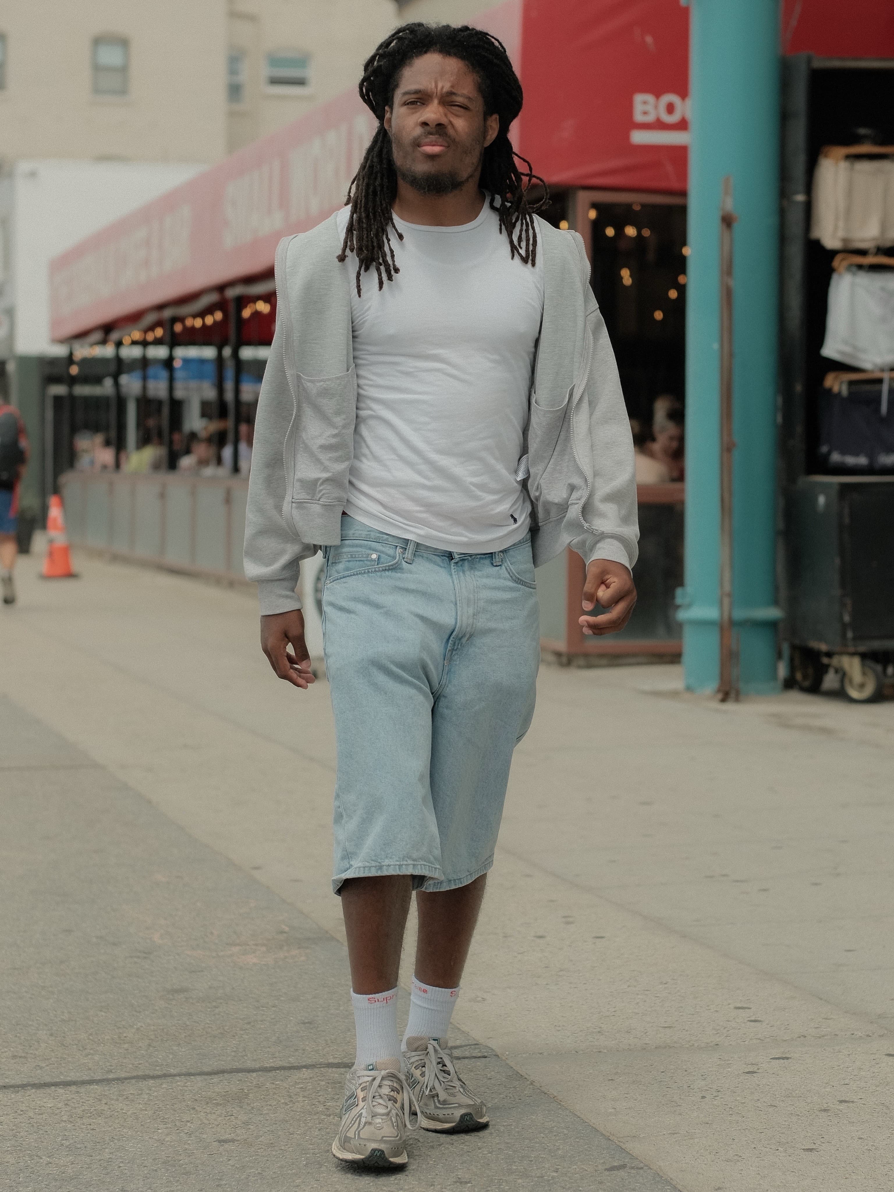 White tee, grey zip hoodie draped, cropped light-wash jorts
