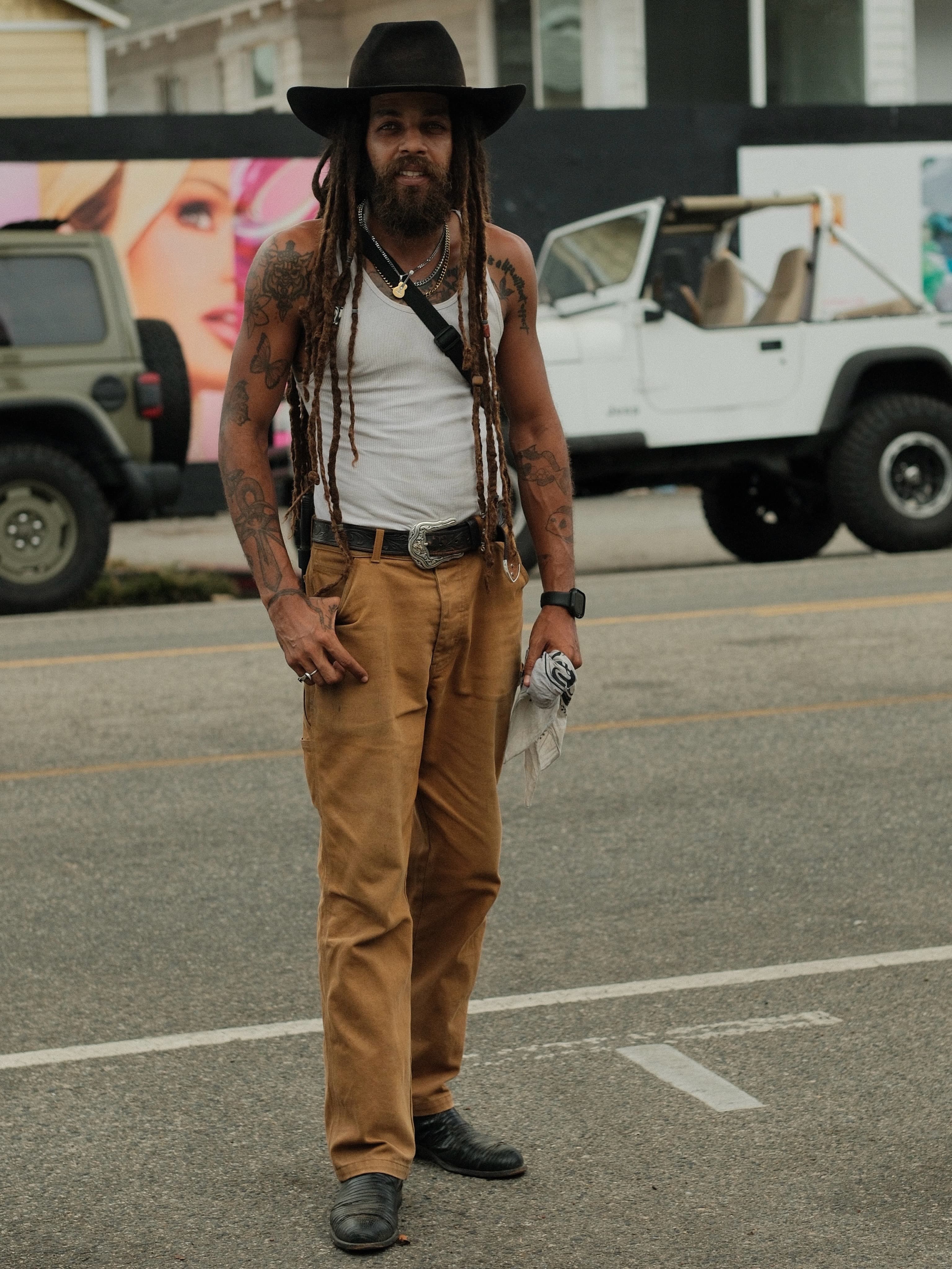Tattoo sleeves, western belt, canvas trousers