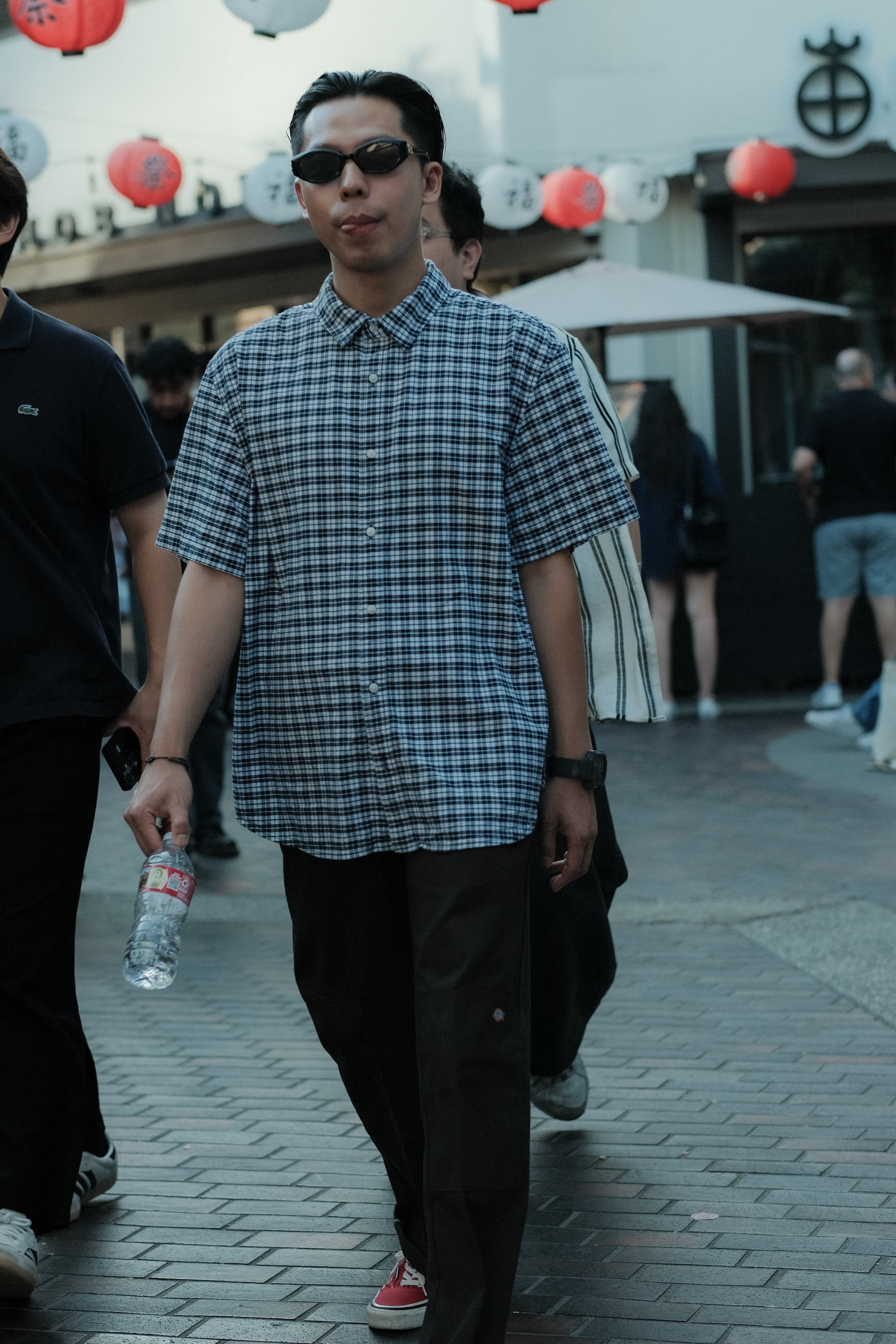 Black-and-white plaid short-sleeve shirt, tapered trousers, red sneakers