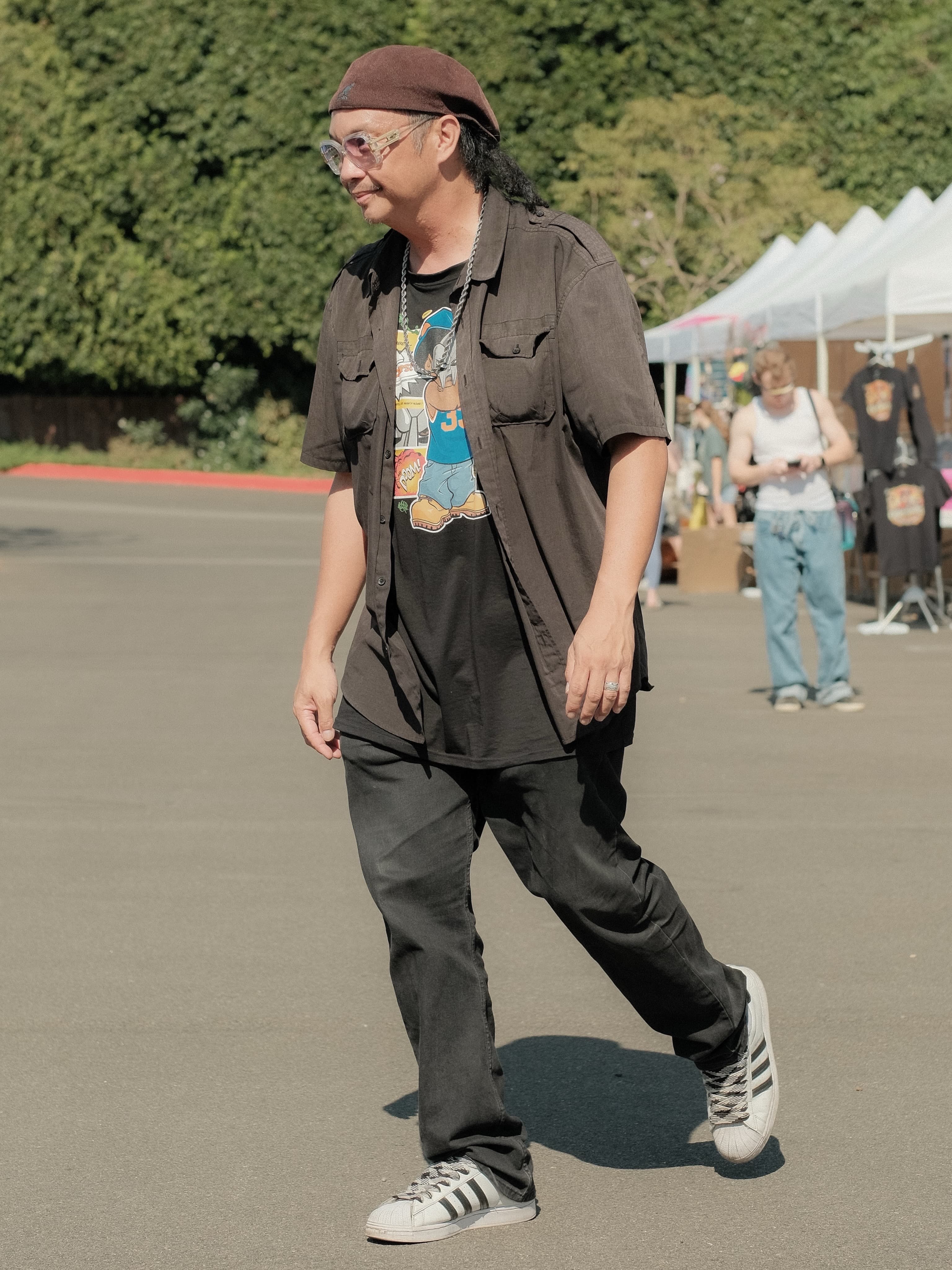 Open brown shirt over a graphic tee, silver chain, brown beret, Adidas Superstars, at Spinning Sunset