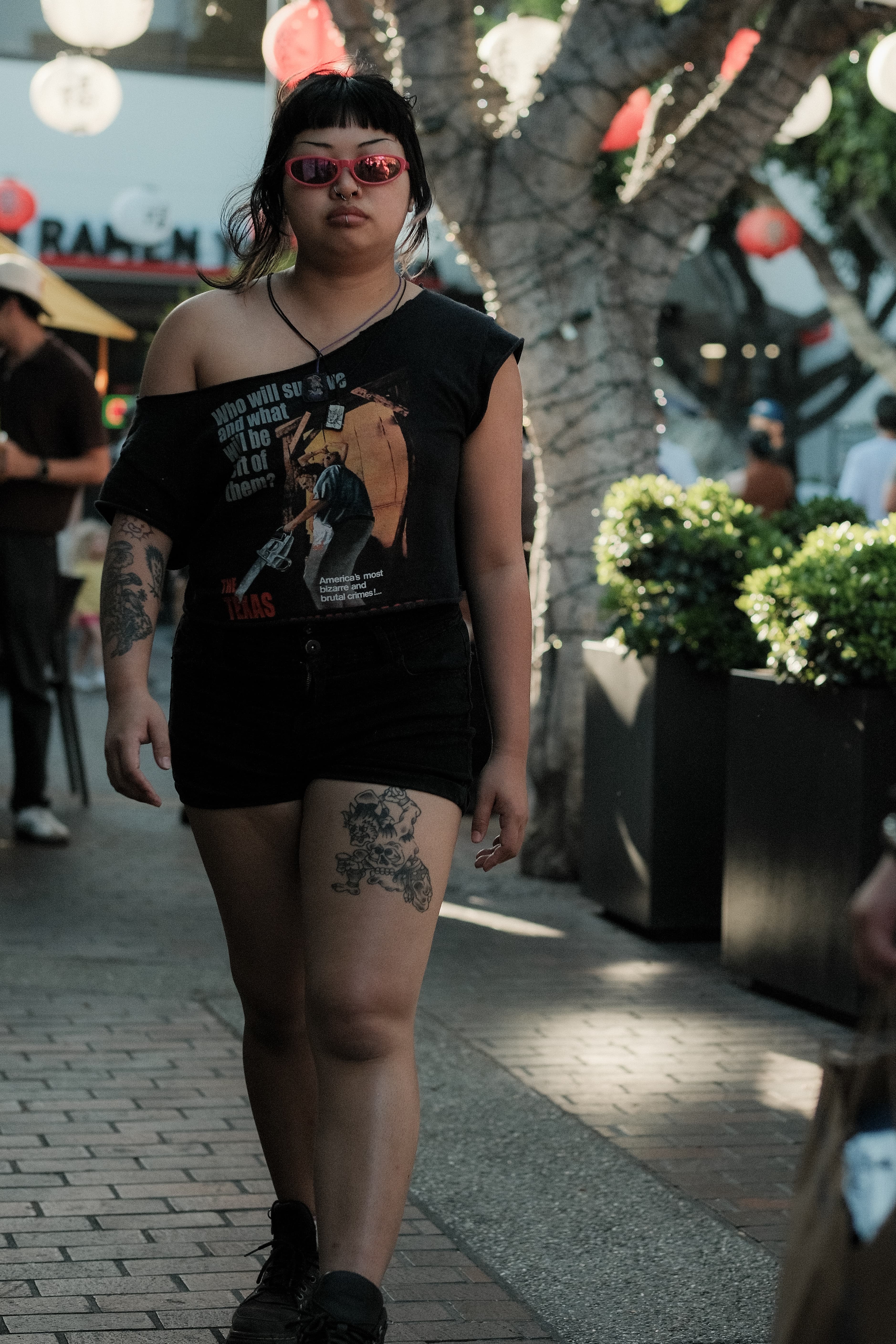 Vintage horror-movie graphic tee, black shorts, pink sunglasses