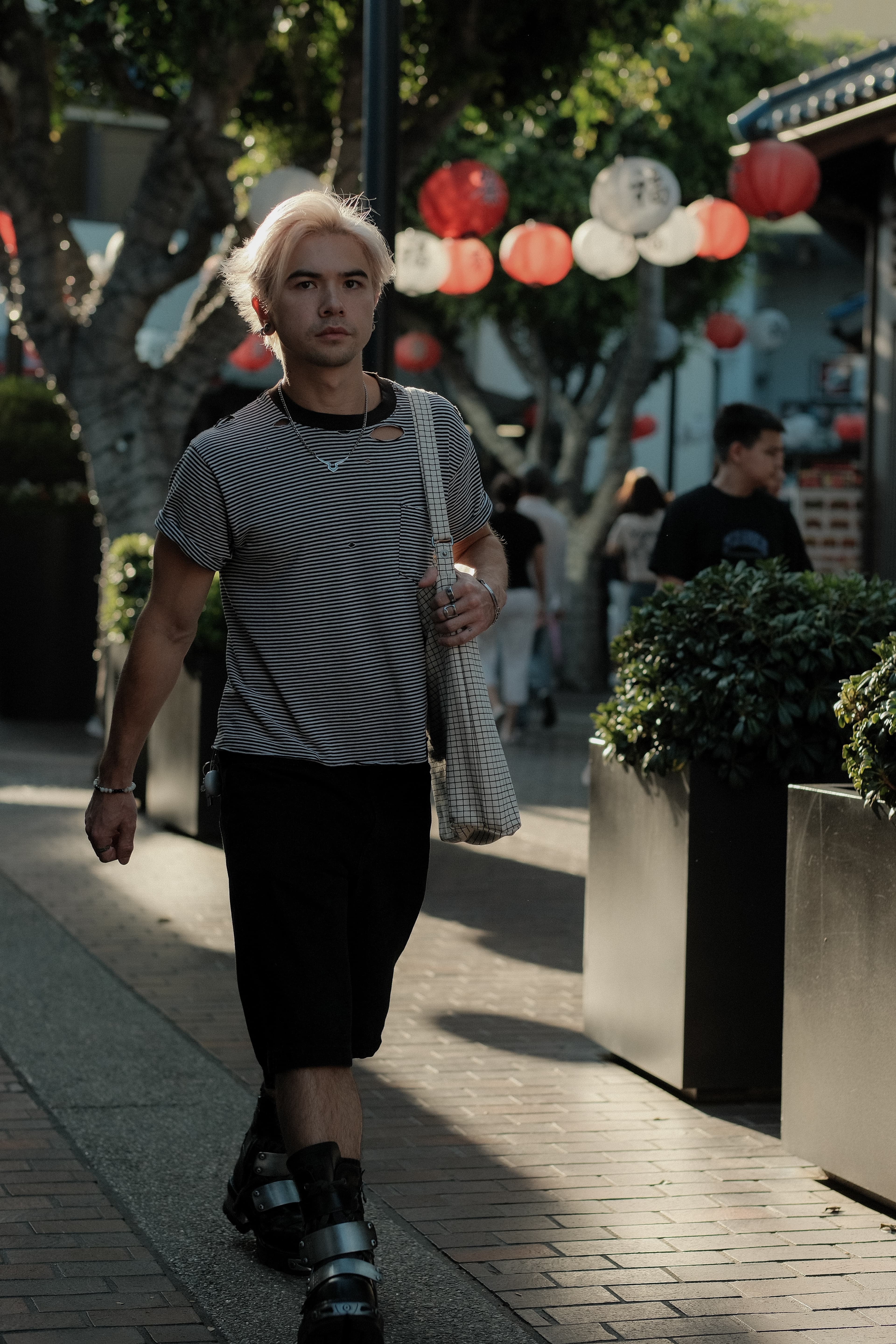 Distressed striped tee, wide black shorts, checked tote