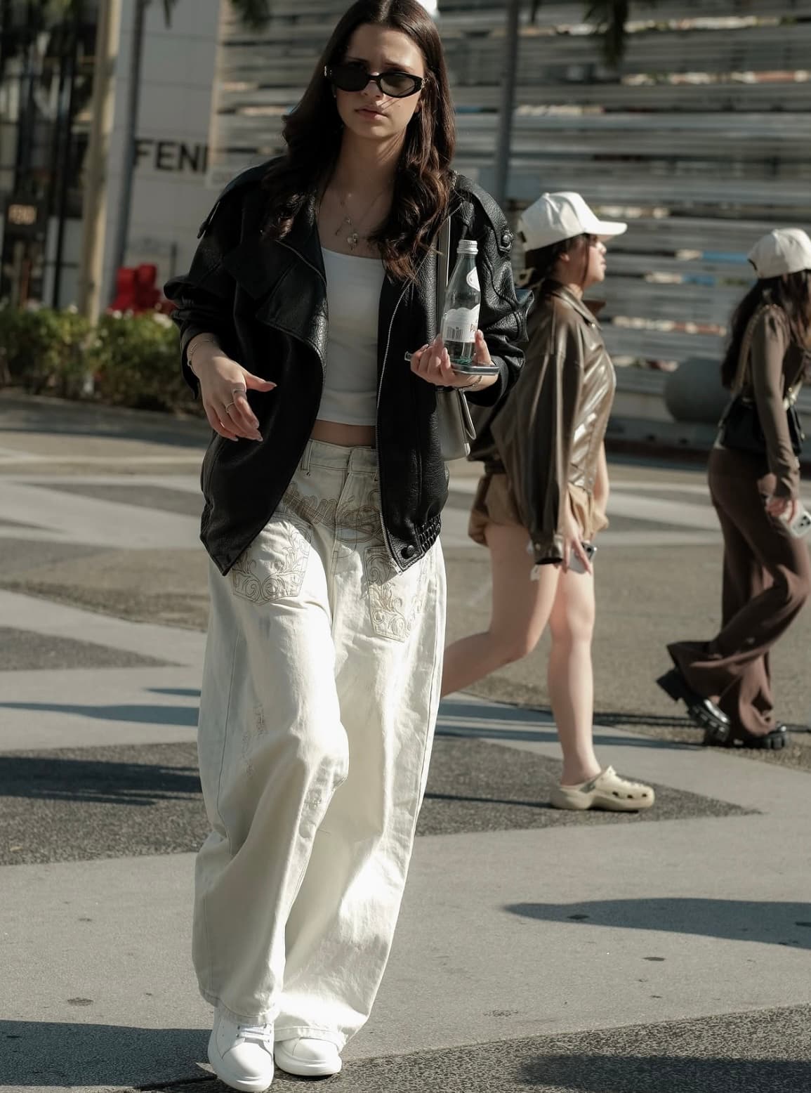 Oversized black leather jacket over a white tank, embroidered cargo trousers