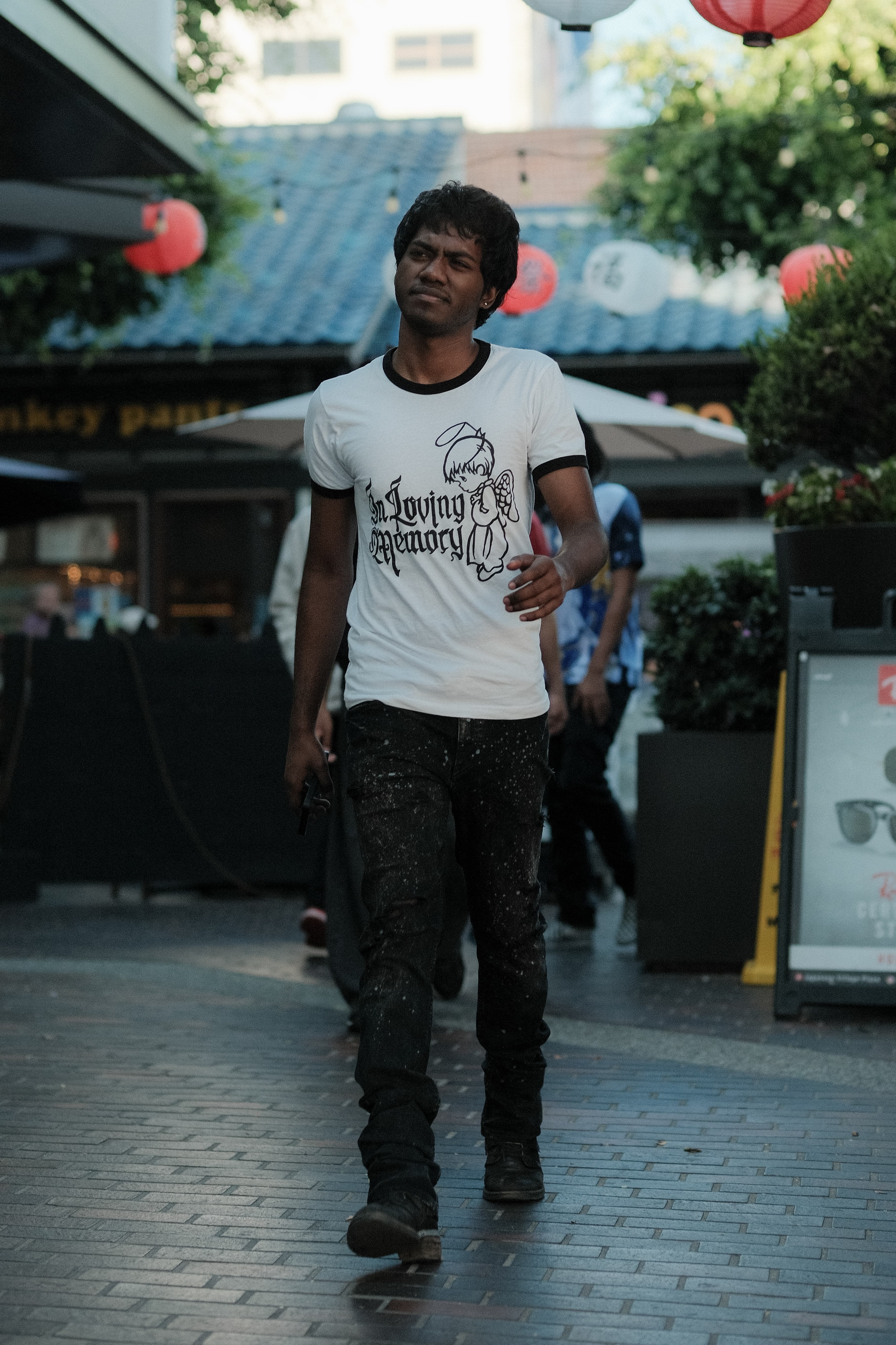 "In Loving Memory" graphic ringer tee, paint-splattered jeans