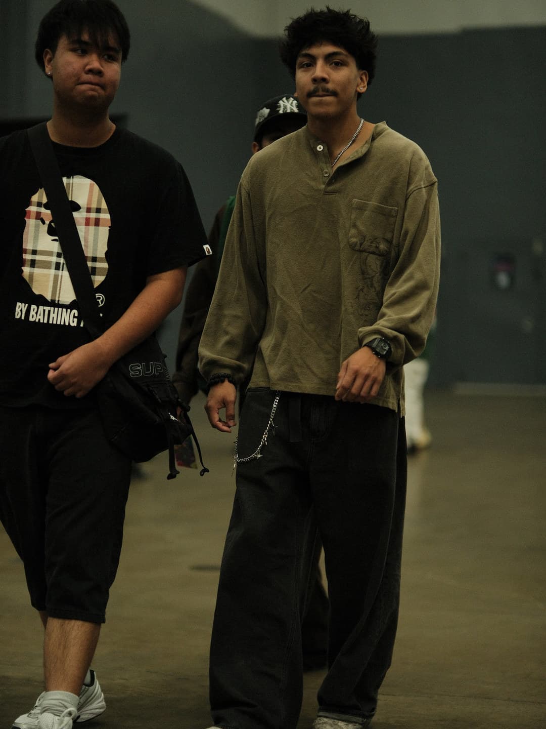 Check-print graphic tee and olive henley, black wide bottoms