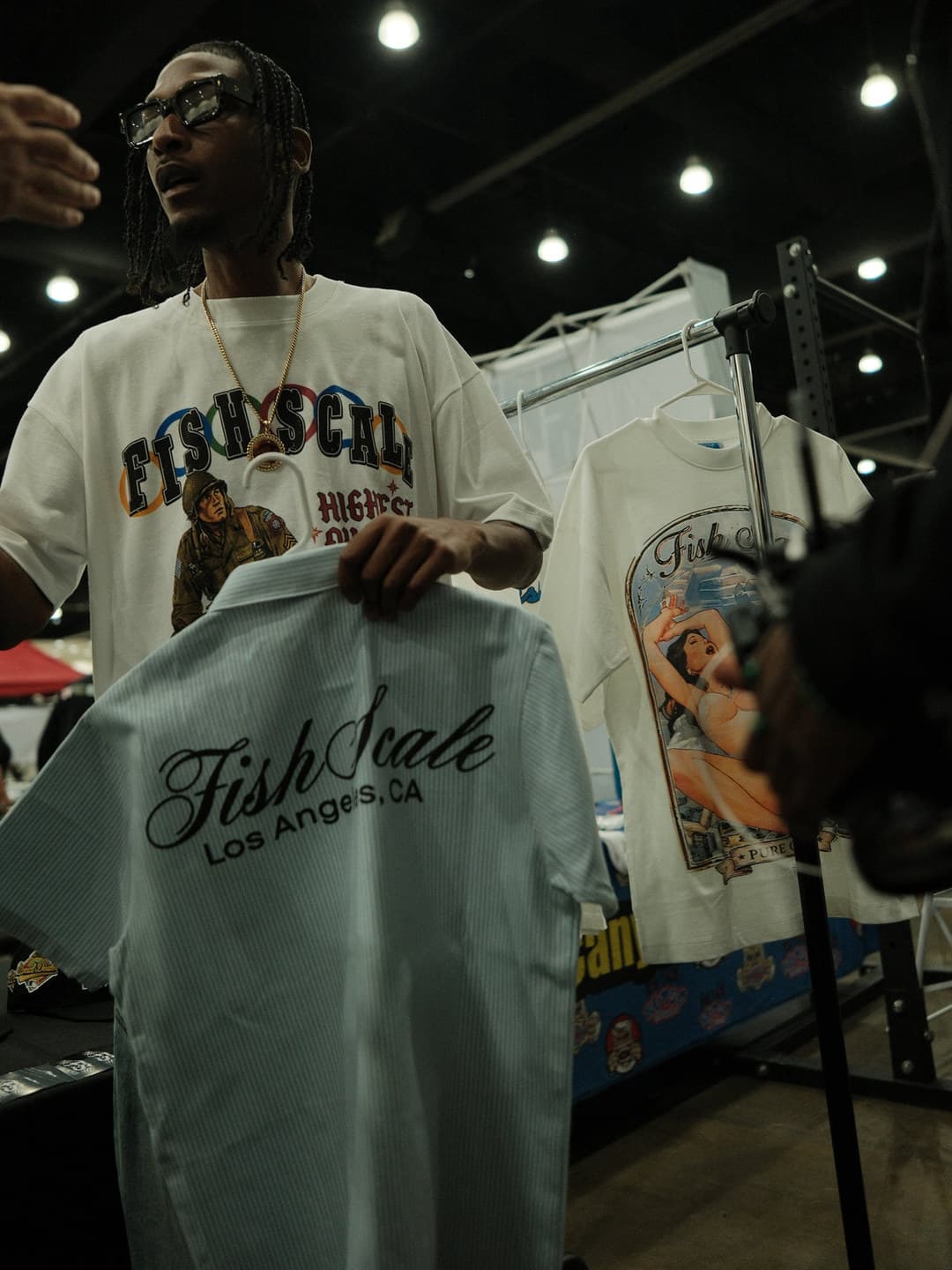 Fish Scale graphic tee, holding a Fish Scale shirt