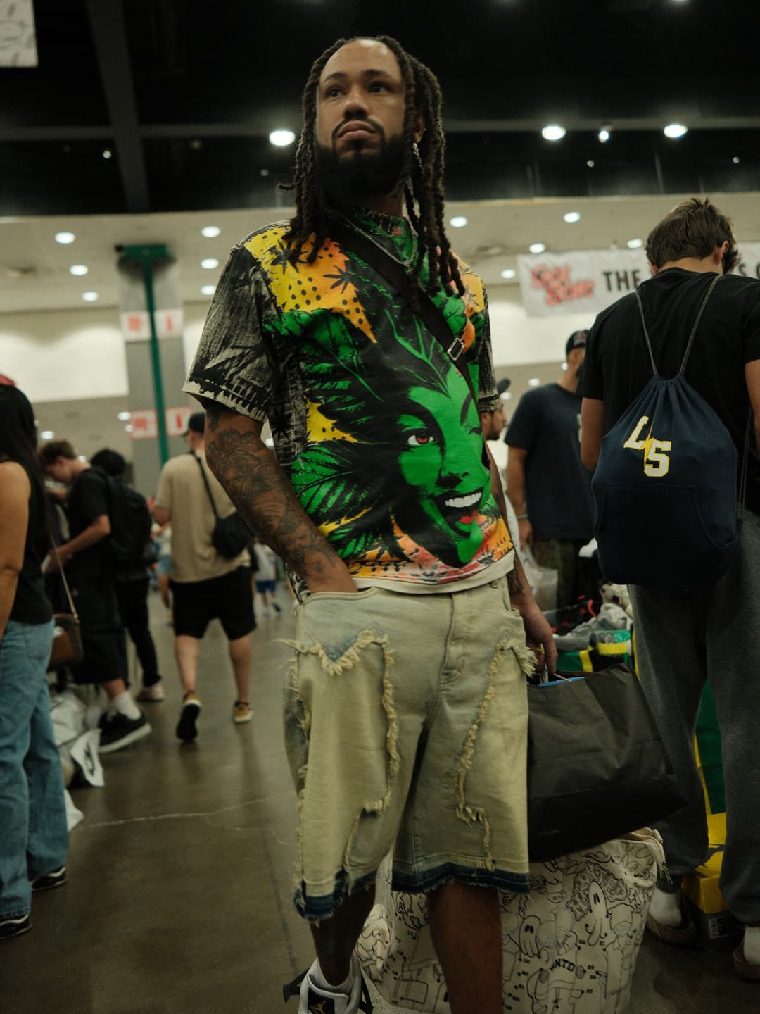Green face-print shirt, frayed denim shorts