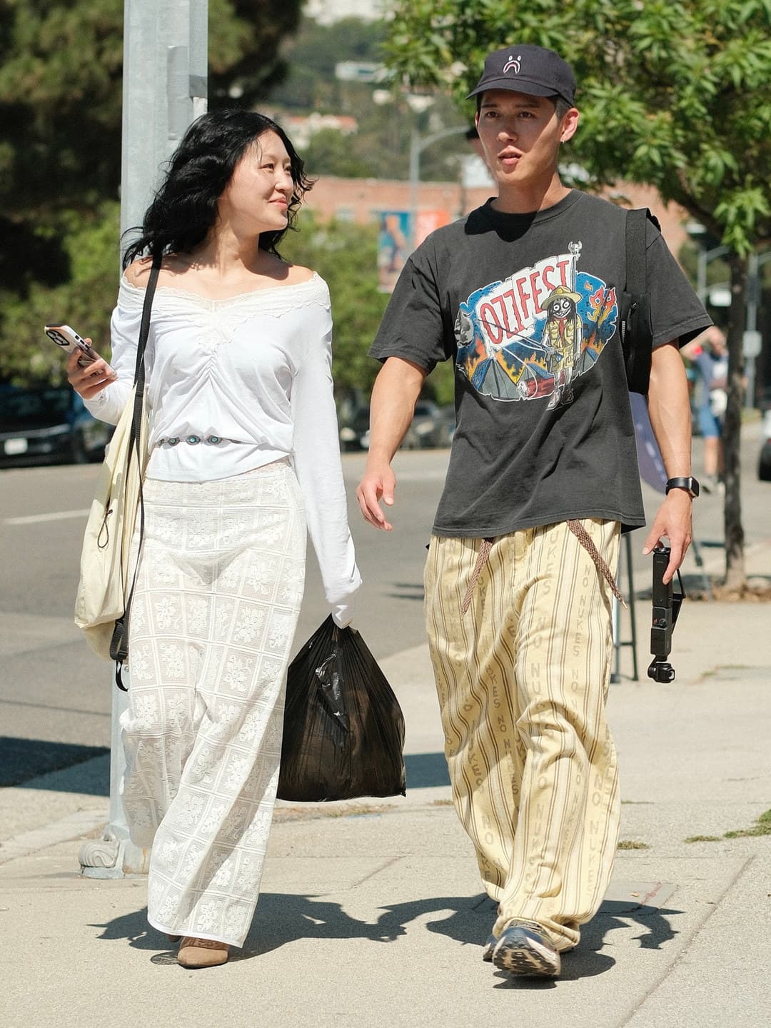 Washed-black Ozzfest graphic tee, pale yellow pinstriped wide-leg trousers