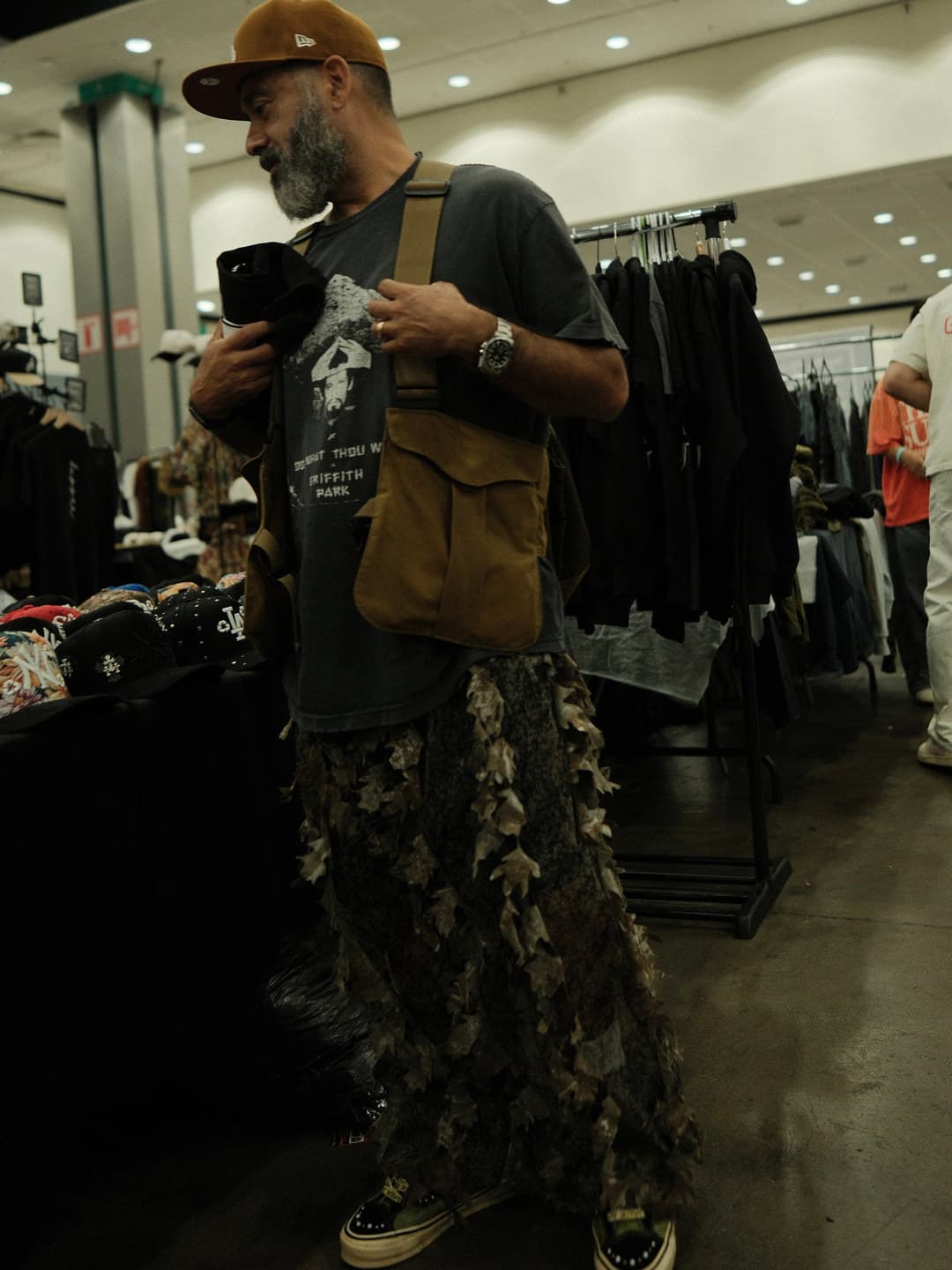 Graphic tee, tan utility bag, long printed skirt