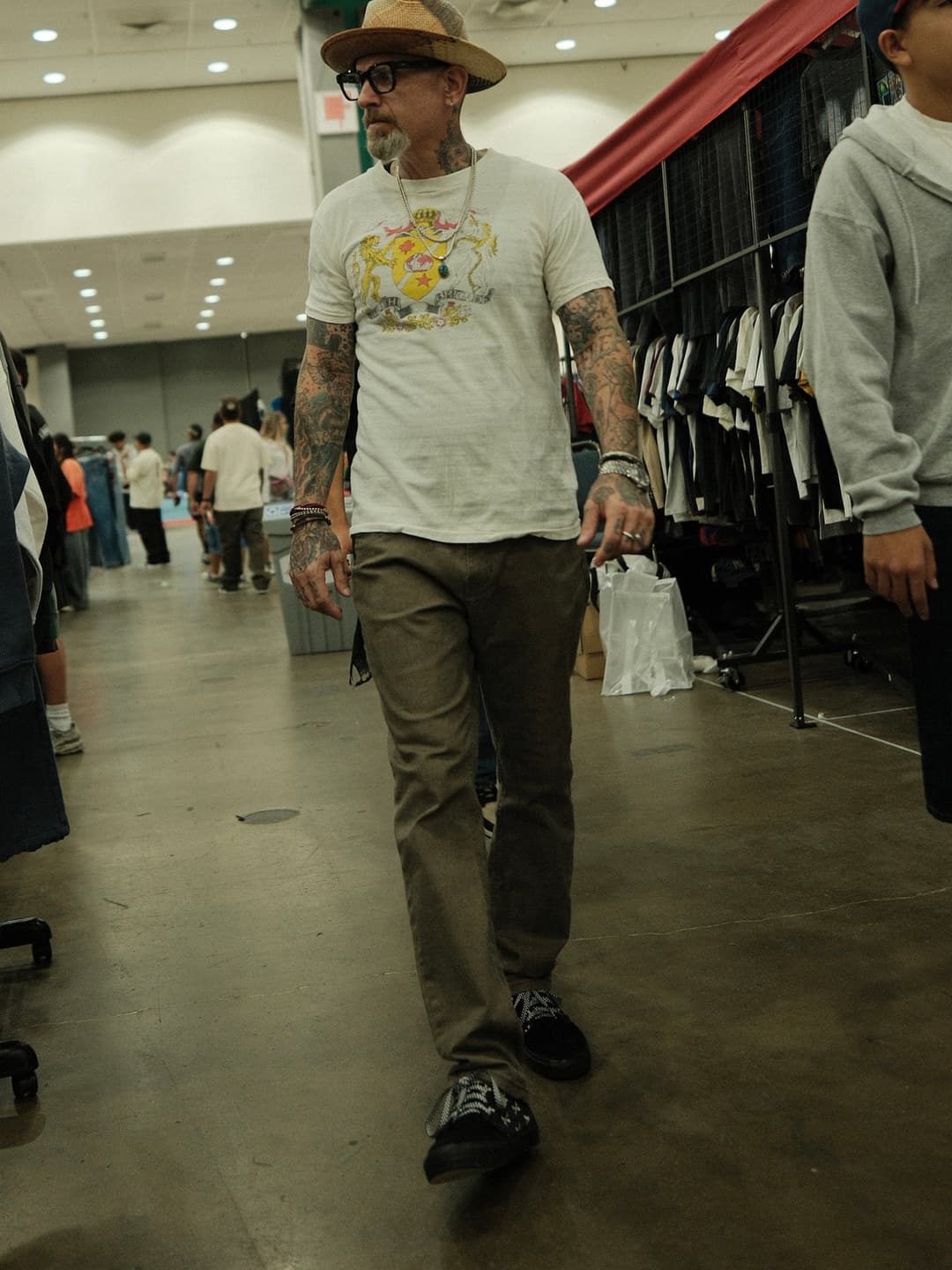White graphic tee, olive trousers, straw fedora